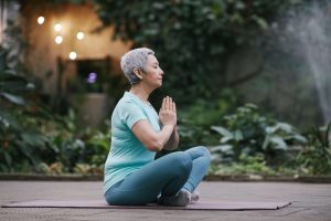 Vrouw mediteert op yogamat